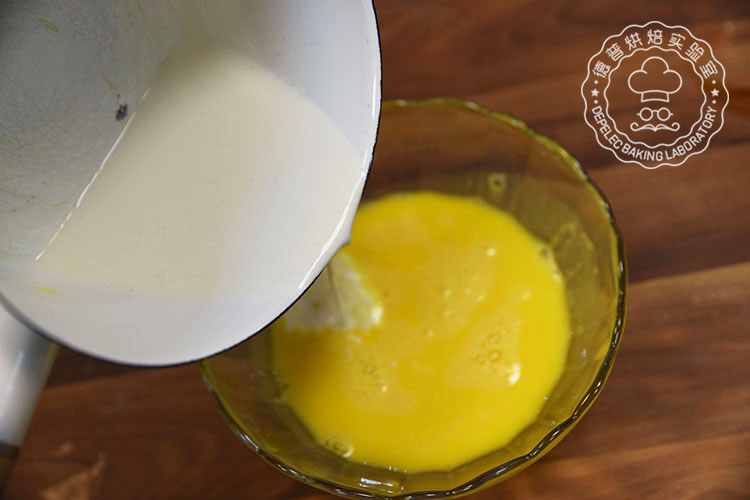 牛奶加热至60度，分次倒入蛋黄液中，混合均匀；