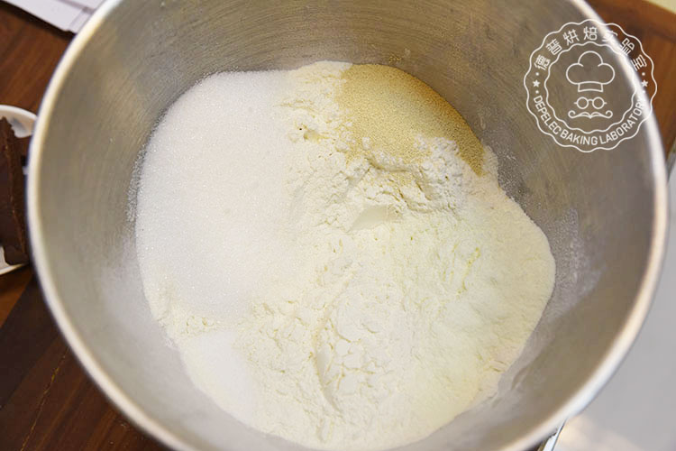 1.将高筋面粉、低筋面粉、奶粉、盐、细糖、酵母、倒入搅拌器皿内，慢速混合1min；