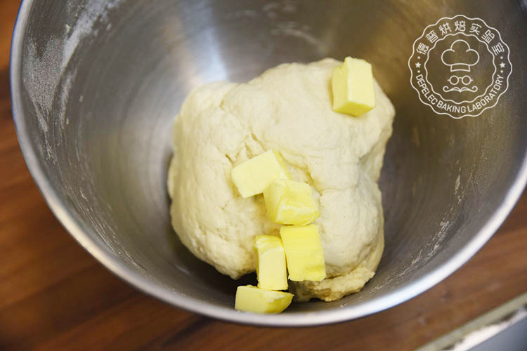 3.加入黄油和盐快速搅拌至面团表面光滑 